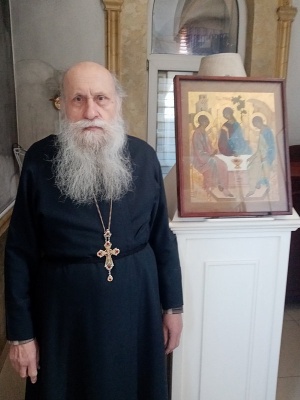 Отец Виктор рядом с иконой Святой Троицы, которую он собственноручно написал.